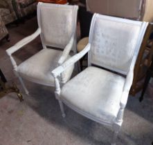 A pair of modern antique style elbow chairs with antiqued cream coloured painted wood frames and