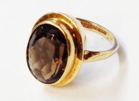 A 375 (9ct.) gold ring, set with large oval smoky quartz stone - size L 1/2