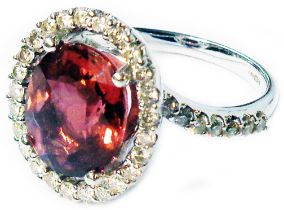 An import marked 585 (14ct.) white gold ring, set with large central oval tourmaline within a