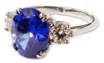 A hallmarked 950 platinum ring, set with central 5.38ct. oval tanzanite flanked by two diamonds -