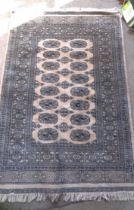 A handmade wool Bokhara rug with repeat gul motifs within a wide border on beige ground - 1.45m X