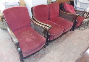 A 20th Century mahogany framed three piece bergere suite with acanthus detail and red upholstered