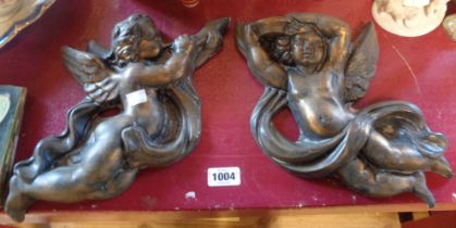 A pair of plaster cherub form wall masks with bronze effect finish