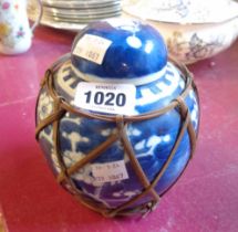 A Chinese porcelain ginger jar and lid with blue painted prunus decoration and basket work sleeve