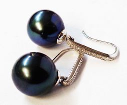 A pair of marked 750 white metal black pearl drop earrings with diamond encrusted suspenders -