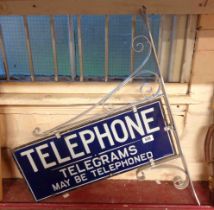 An original G.P.O. Telephone enamel sign and wall mounting bracket with white lettering on blue