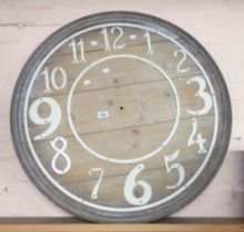 A large decorative wooden clock face with white painted cutout numbers - no hands