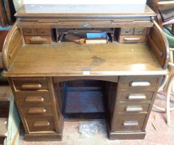 A 1.02m vintage polished oak roll-top desk with fitted interior enclosed by a tambour, flanking