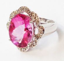 An import marked 585 (14ct.) white gold ring, set with large central oval pink topaz within a shaped