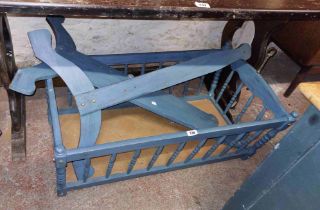 A vintage blue painted swinging crib with shaped standard ends