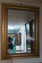 A modern gilt framed bevelled oval wall mirror