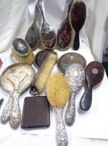 A collection of silver mounted tortoiseshell pique work dressing table brushes and hand mirrors,