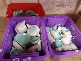 Three crates containing a quantity of vintage Poole Pottery tableware in the Pebble and Ice Green