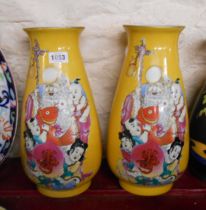 A pair of 20th Century porcelain vases each decorated with a central panel, depicting a deity and