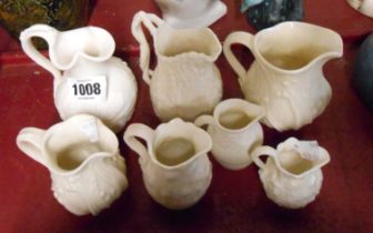 Seven Victorian and later small parian ware relief moulded jugs
