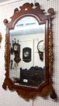 A Georgian style walnut and parcel gilt fretwork framed wall mirror with break arch top and bevelled