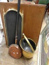 A brass coal scuttle of helmet form - sold with a brass framed wire meshed folding fire guard and