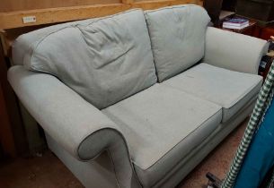A 2m modern two seater settee with pale blue upholstery, set on casters