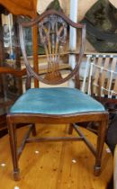 A set of four mahogany framed Hepplewhite style shield back dining chairs with upholstered drop-in