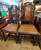 A pair of late Victorian stained oak framed ornate high back dining chairs with rattan backs and