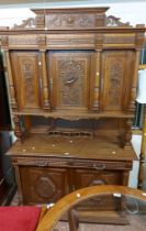 A 1.4m 20th Century French ornate carved oak break top two part cabinet with triple cupboard to top