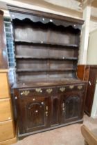 A 1.25m antique oak two part dresser with three shelf open plate rack, two frieze drawers and pair