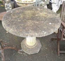 A 90cm diameter concrete table, set on a fluted pillar and octagonal base