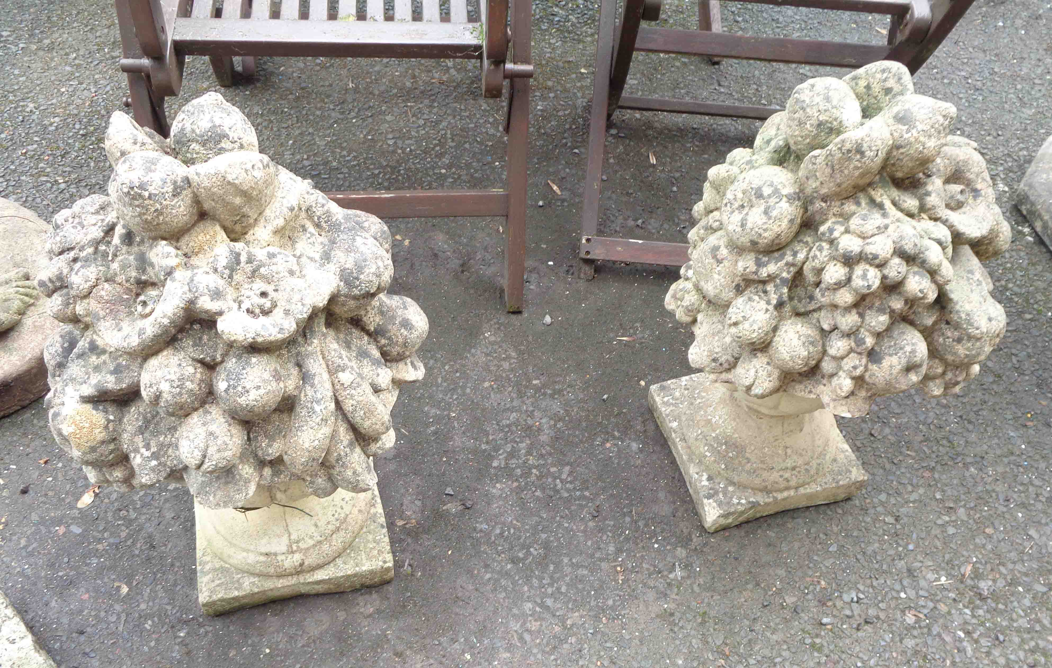 A pair of 60cm high concrete statues, in the form of an urn full of fruit