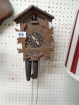 A vintage tourist ware stained wood cuckoo wall clock with twin metal acorn pattern weight driven