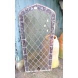 A leaded stained glass arched window with decorative border