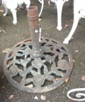 A cast metal parasol base with floral decoration