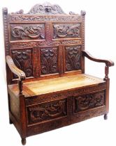 A 1.06m late Victorian carved oak high panel back bench with stylised mask and dolphin decoration,