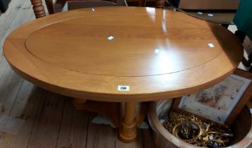 A 100cm modern polished golden oak coffee table with oval top, set on turned supports with shaped