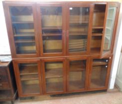 A 1.82m mixed wood two part book cabinet with adjustable shelves enclosed by eight glazed panel