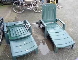 A pair of modern green plastic folding garden elbow chairs