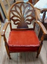 An early 20th Century stained wood framed low elbow chair with pierced decorative back - sold with a