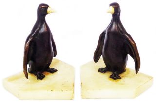 A pair of Art Deco alabaster bookends, set with bronze penguin figures with carved bone beaks
