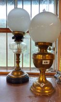 An old oil lamp with cut glass reservoir, brass column and ceramic base with an opaque glass shade