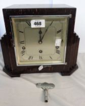 An Art Deco stained oak mantel clock with stepped sides and Garrard eight day chiming movement