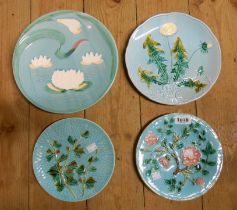 Four continental majolica plates with various moulded designs and coloured lead glazes