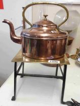 A vintage copper kettle with brass handle - sold with a brass and wrought iron trivet