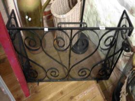 A wrought iron and mesh fire fender with black painted finish