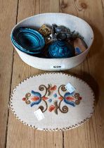 An oval fabric covered box with embroidered decoration containing a small quantity of collectable