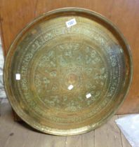 An Indian brass tray with embossed decoration
