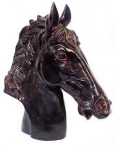 A large cast metal horse's head sculpture with bronzed finish