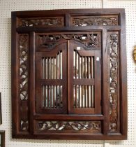 An eastern stained wood framed 'window' wall mirror with decorative fretwork panelled border and