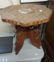 A small Indian carved hardwood tea table, set on a pierced folding base