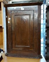 A 57cm antique oak wall hanging corner cupboard enclosed by a single panelled door - wear