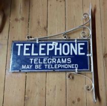 An original G.P.O. Telephone enamel sign and wall mounting bracket with white lettering on blue