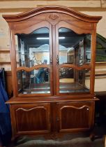 A 1.4m modern stained mixed wood two part display cabinet with glass shelves enclosed by a pair of